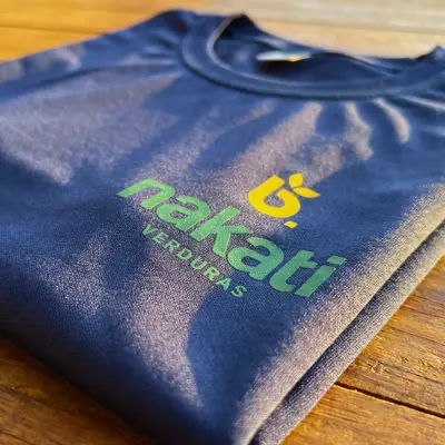 Camiseta azul-marinho com o logo da Nakati Verduras estampado no peito