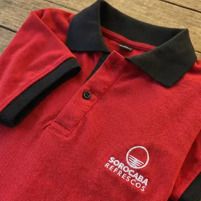 Polo vermelha e preta com o logo da Sorocaba Refrescos bordado no peito