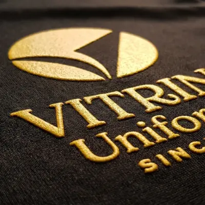 Logo em silk alto relevo dourado sobre tecido preto